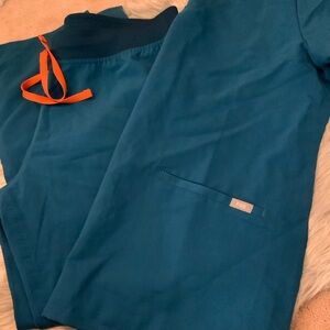 Figs scrub set in large petite. Pants have no pockets. Shirt has 2 bottom pocket